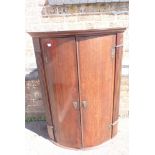 A GEORGE III OAK BOWFRONT HANGING CORNER CUPBOARD