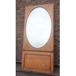 A BEVELLED OVAL MIRROR, IN AN OAK FRAME