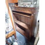 AN OAK OPEN BOOKCASE WITH CARVED DECORATION