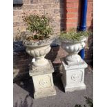 A PAIR OF RECONSTITUTED STONE GARDEN URNS