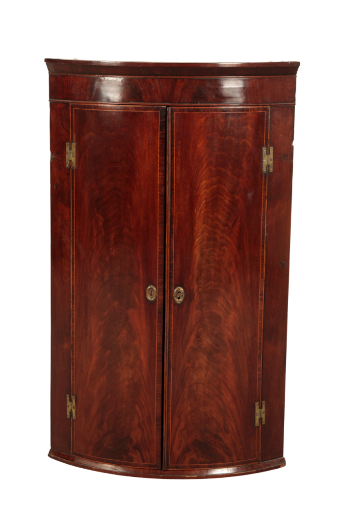 A GEORGE III MAHOGANY BOW-FRONT HANGING CORNER CUPBOARD