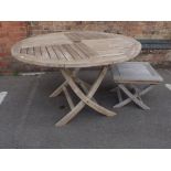 A WEATHERED TEAK CIRCULAR GARDEN TABLE