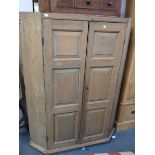 A GEORGE III STRIPPED PINE CORNER CUPBOARD