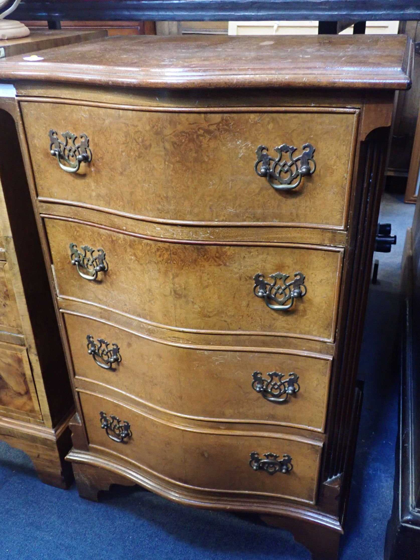 A FIGURED WALNUT SERPENTINE FRONT BEDSIDE CHEST