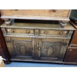 AN OAK SIDEBOARD WITH CARVED ARCHED PANEL DOORS