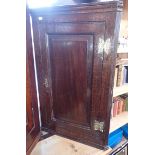 A SMALL GEORGE III OAK HANGING CORNER CUPBOARD