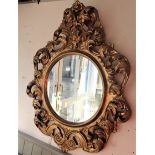 A ROCOCO GILTWOOD OVAL MIRROR