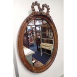 AN EDWARDIAN WALNUT FRAMED OVAL WALL MIRROR