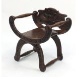 Walnut X frame chair carved with mythical animals and foliage, 65cm high