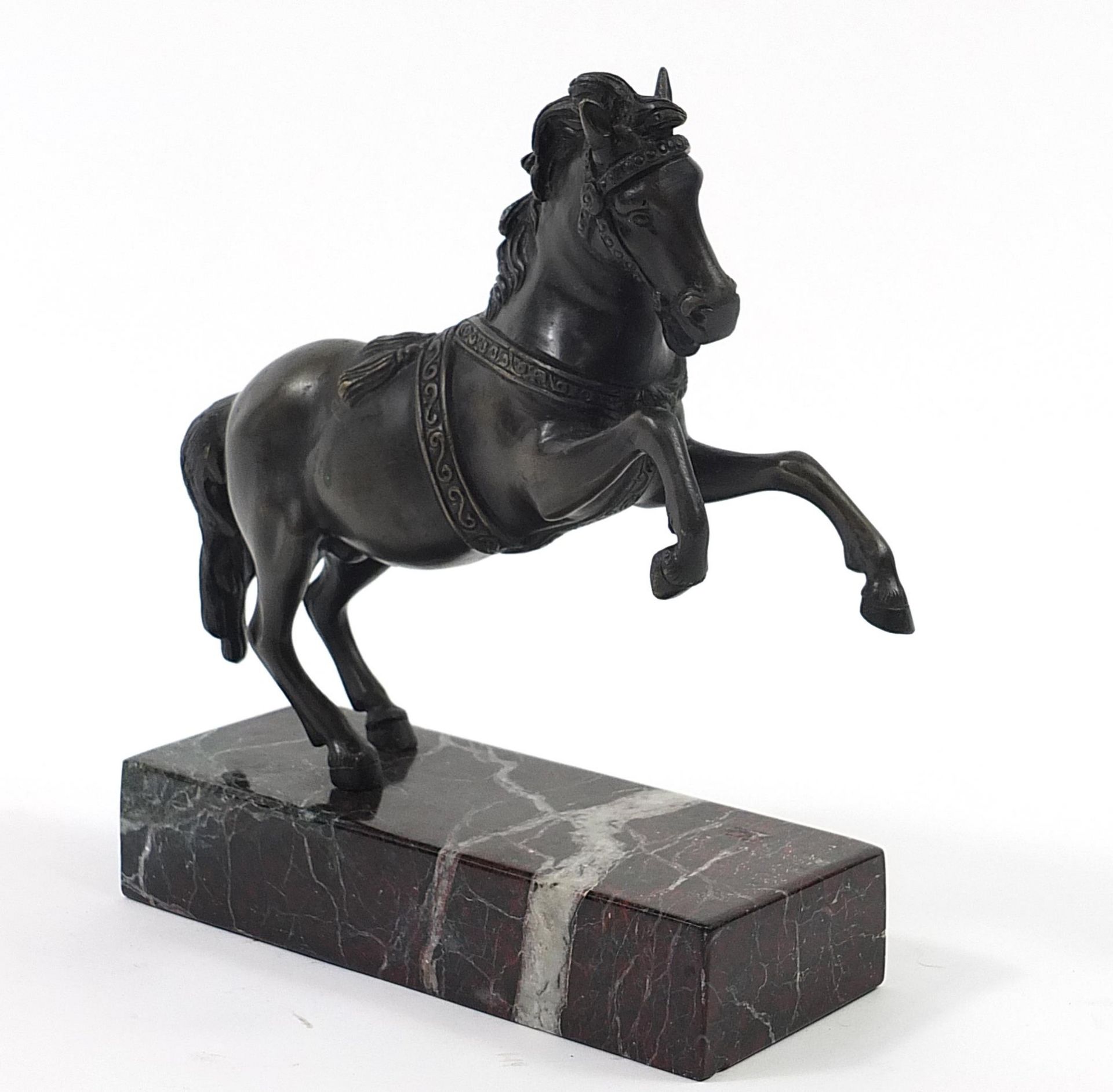 After Minati, patinated bronze rearing horse raised on a marble base, 24cm high Overall in generally