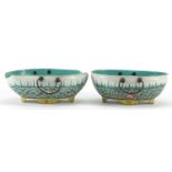 Two Chinese porcelain four footed bowls with metal handles, each finely hand painted with crashing