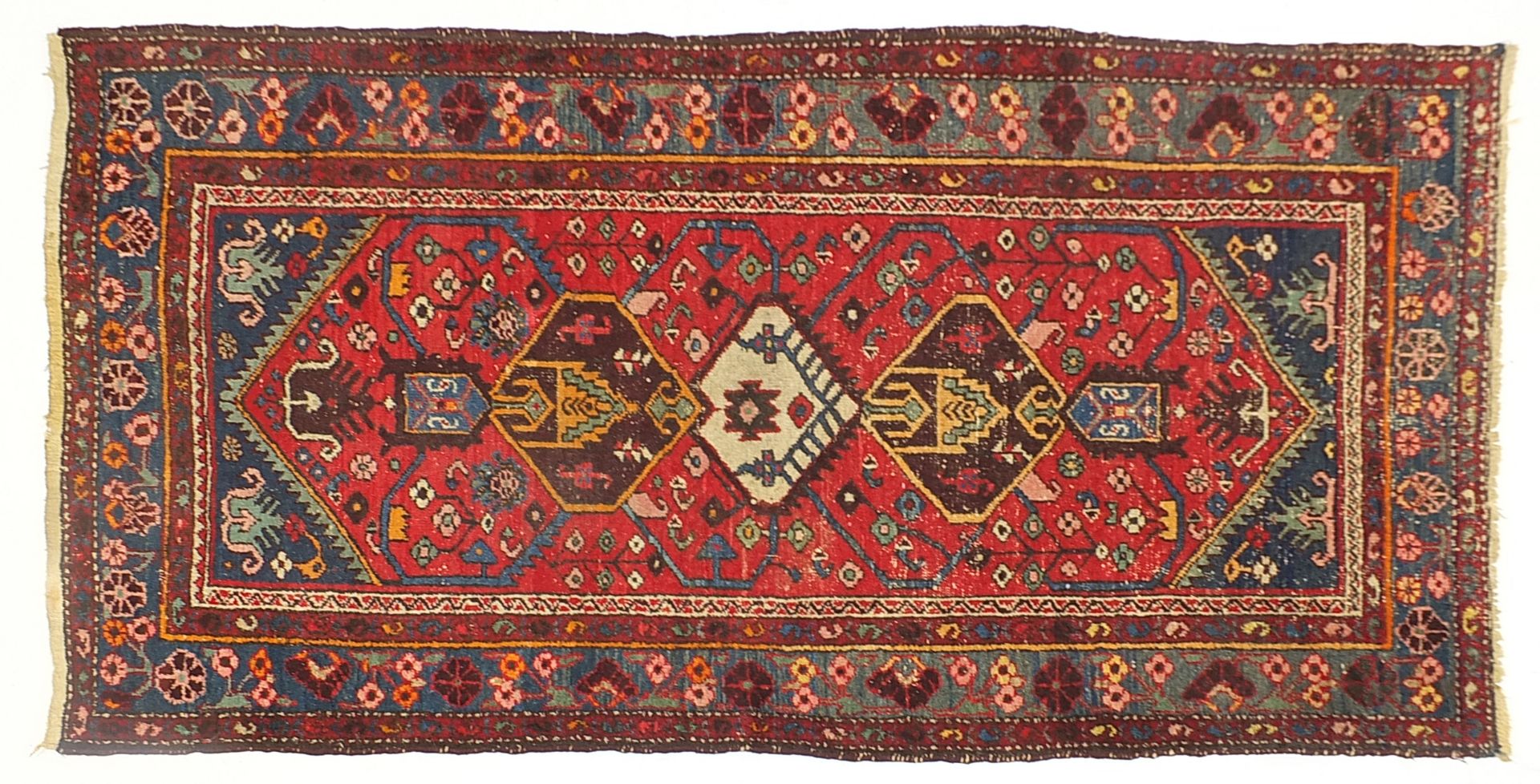 Red and blue ground rug with geometric design, 205cm x 110cm