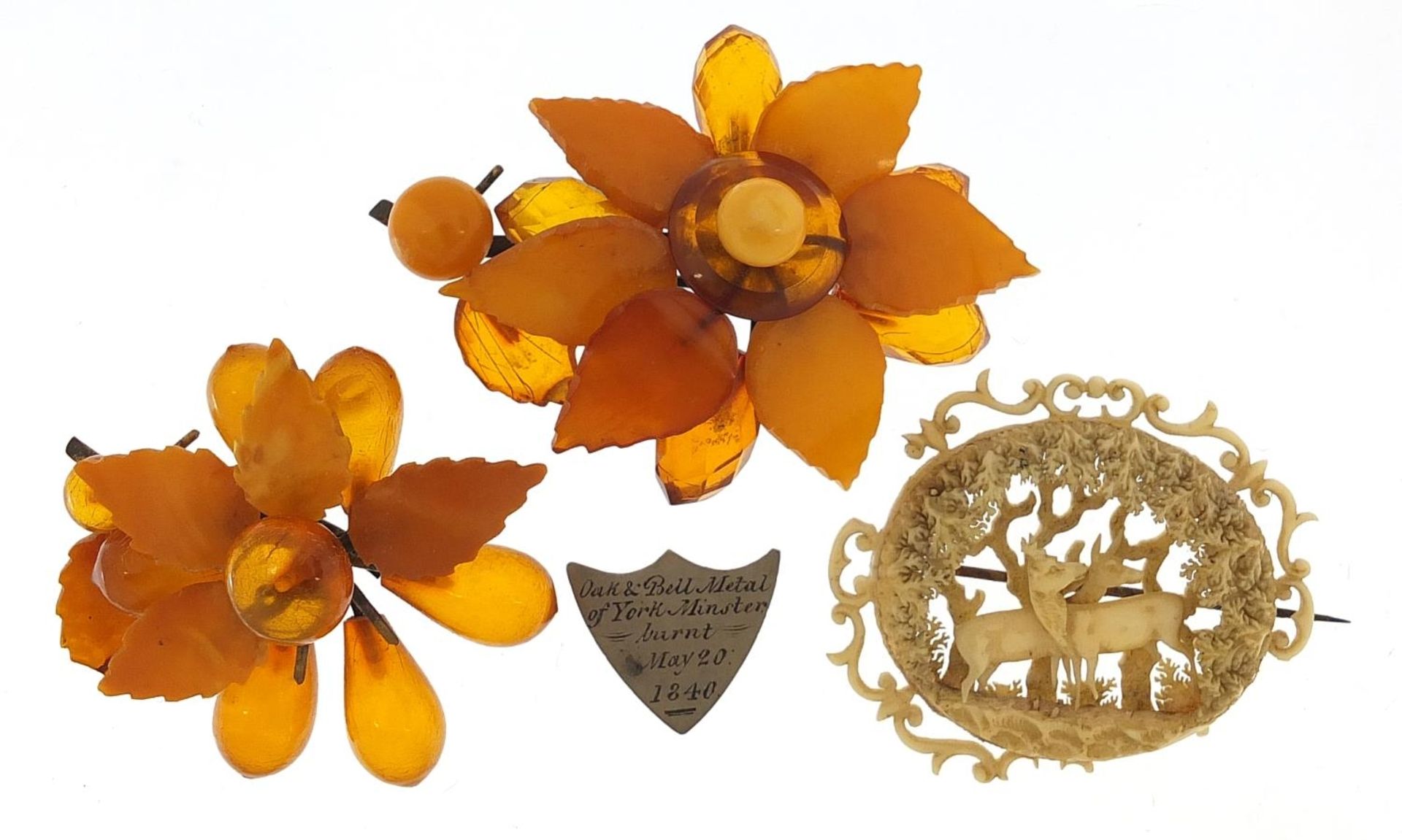 Antique jewellery comprising two amber coloured floral brooches, carved ivory brooch and a silver