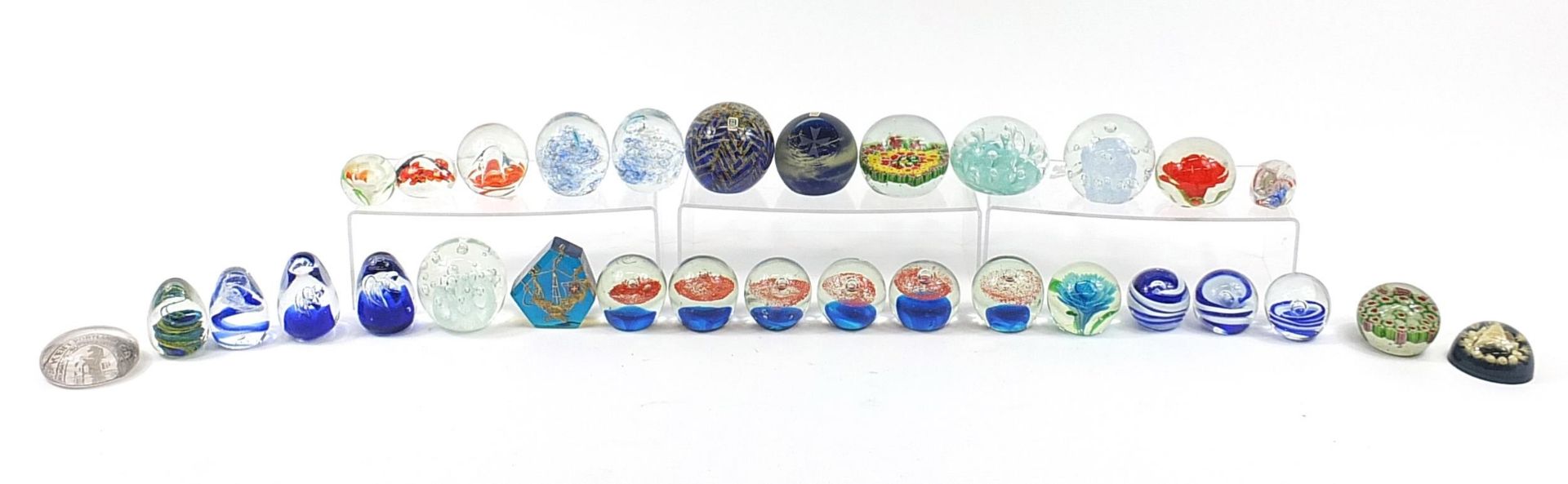 Collection of colourful glass and celluloid paperweights including Mdina, the largest