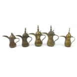 Five Omani brass dallah coffee pots, the largest 31.5cm high