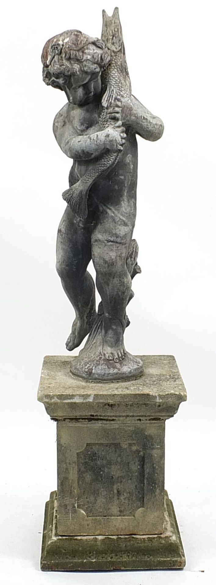 Lead garden water feature of Putti holding a fish, raised on a square concrete base, 145cm high