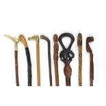 Eight tribal interest wooden walking sticks including one with antler horn handle, each