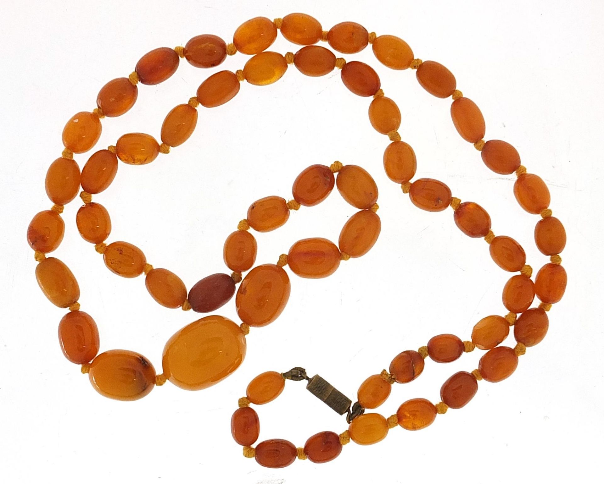 Butterscotch amber coloured graduated bead necklace, the largest bead 2.2cm in length, the