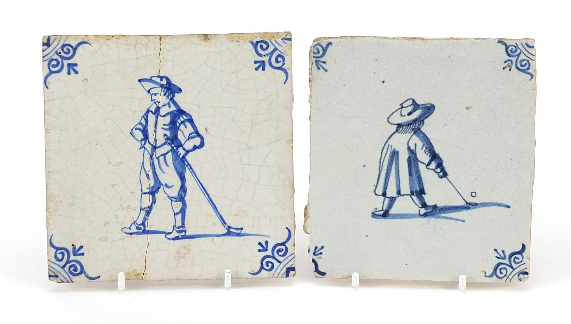 Two antique Delft tiles hand painted with figures playing golf, the largest 13cm x 13cm, the other