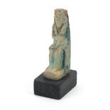 Egyptian style stone figure raised on a wooden base, overall 10cm high