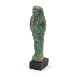 Egyptian style ushabti raised on a wooden base, overall 16.5cm high