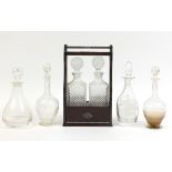 Four cut glass decanters and a mahogany tantalus with two decanters, the largest 36cm high