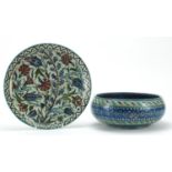Middle Eastern Iznik style pottery comprising a plate and bowl, each hand painted with flowers,