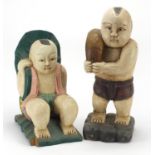 Two Chinese painted carved wood figures of young boys, the largest 39cm high