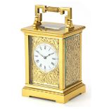 French brass cased repeating carriage clock with fret panels and enamelled dial, the backplate and