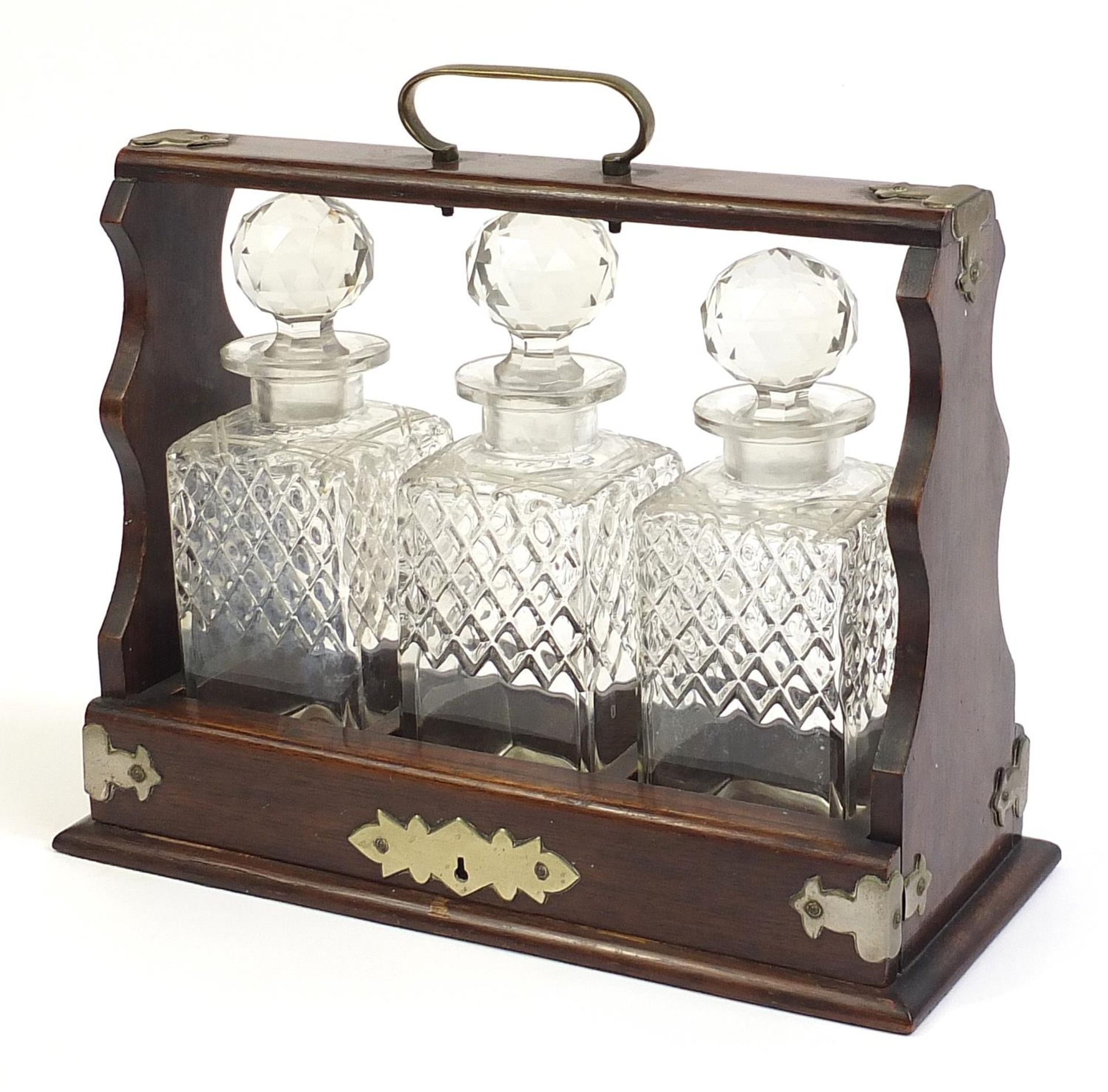 Oak three bottle tantalus with three glass decanters, 35.5cm wide
