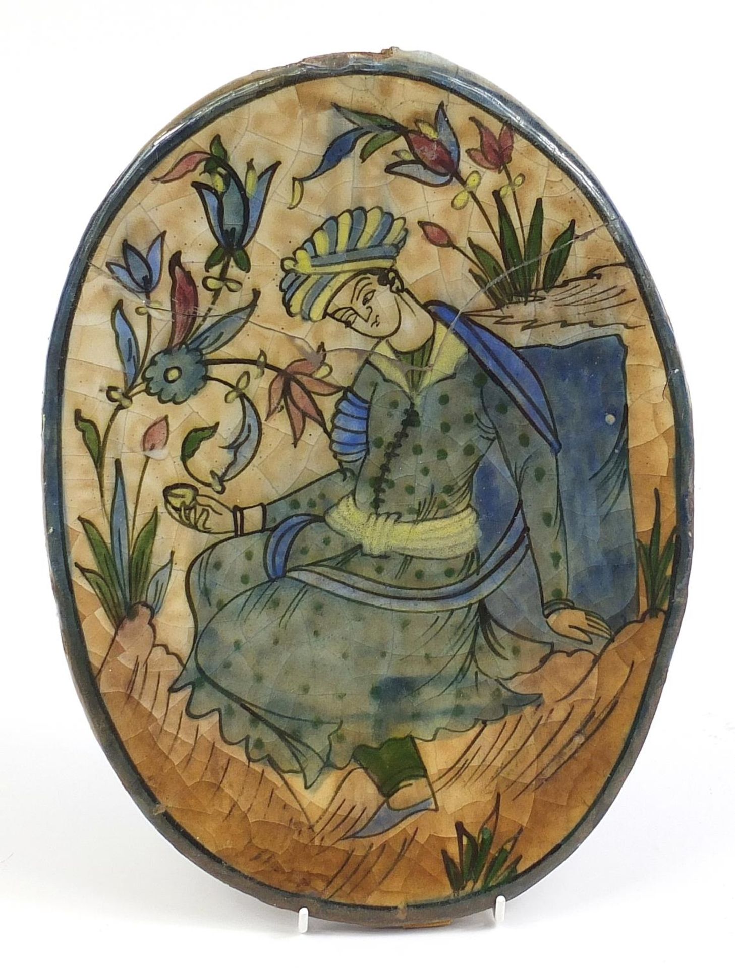 Persian oval pottery tile hand painted with a figure, 36cm high