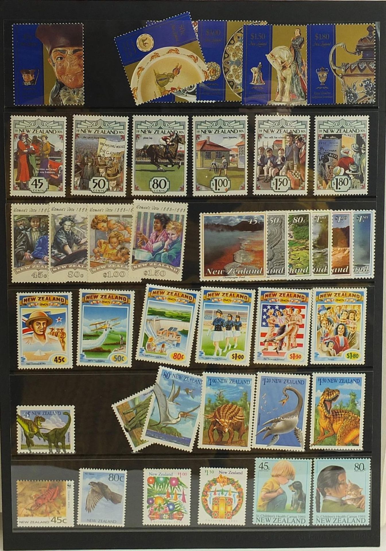 Collection of New Zealand stamps arranged in an album and a black stock sheet of unmounted stamps