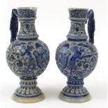 Pair of German salt glazed jugs decorated with grotesque masks and foliage, 28cm high