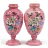 Pair of Victorian pink overlaid glass vases enamelled with flowers, each 28cm high