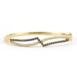 18ct gold diamond and sapphire crossover hinged bangle, 6.5cm wide, 17.5g