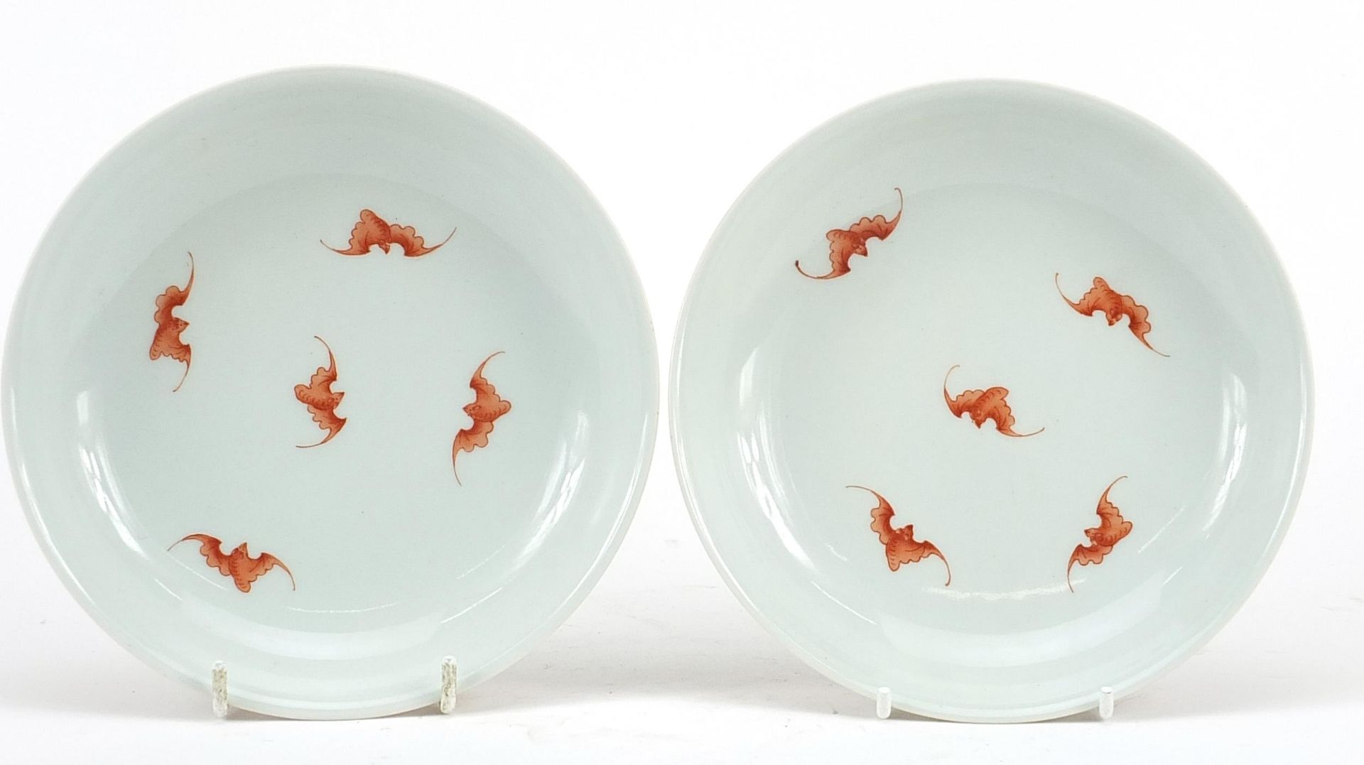 Pair of Chinese porcelain shallow dishes hand painted in iron red with bats and flower heads amongst