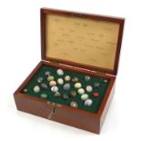 Birdseye maple box containing twenty five specimen stone eggs including serpentine, petrified