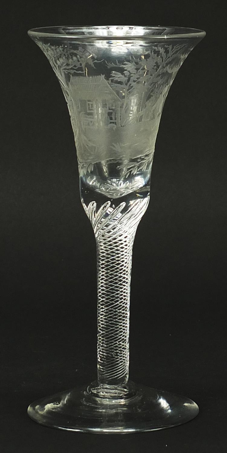 18th century wine glass with air twist stem and bell shaped bowl etched with figures beside a hut