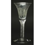 18th century wine glass with air twist stem and bell shaped bowl etched with figures beside a hut