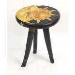 Hand painted tripod occasional table carved with a moon and sun face, 60cm high x 47cm in diameter