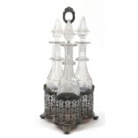 Three cut glass decanters housed in a silver plated tantalus, 42cm high