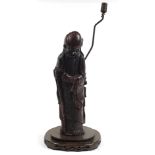 Chinese carved foot wood floor standing lamp in the form of an Elder holding fruit, 82cm high