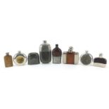 Seven vintage hip flasks, some with leather mounts, the largest 17.5cm high