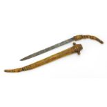 Tribal interest bone sword with and engraved blade, carved figural handle and carved sheath, 45.