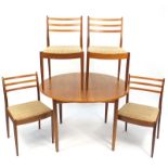 1970's G Plan teak circular extending dining table and four chairs, the table 72.5cm high x 112cm in