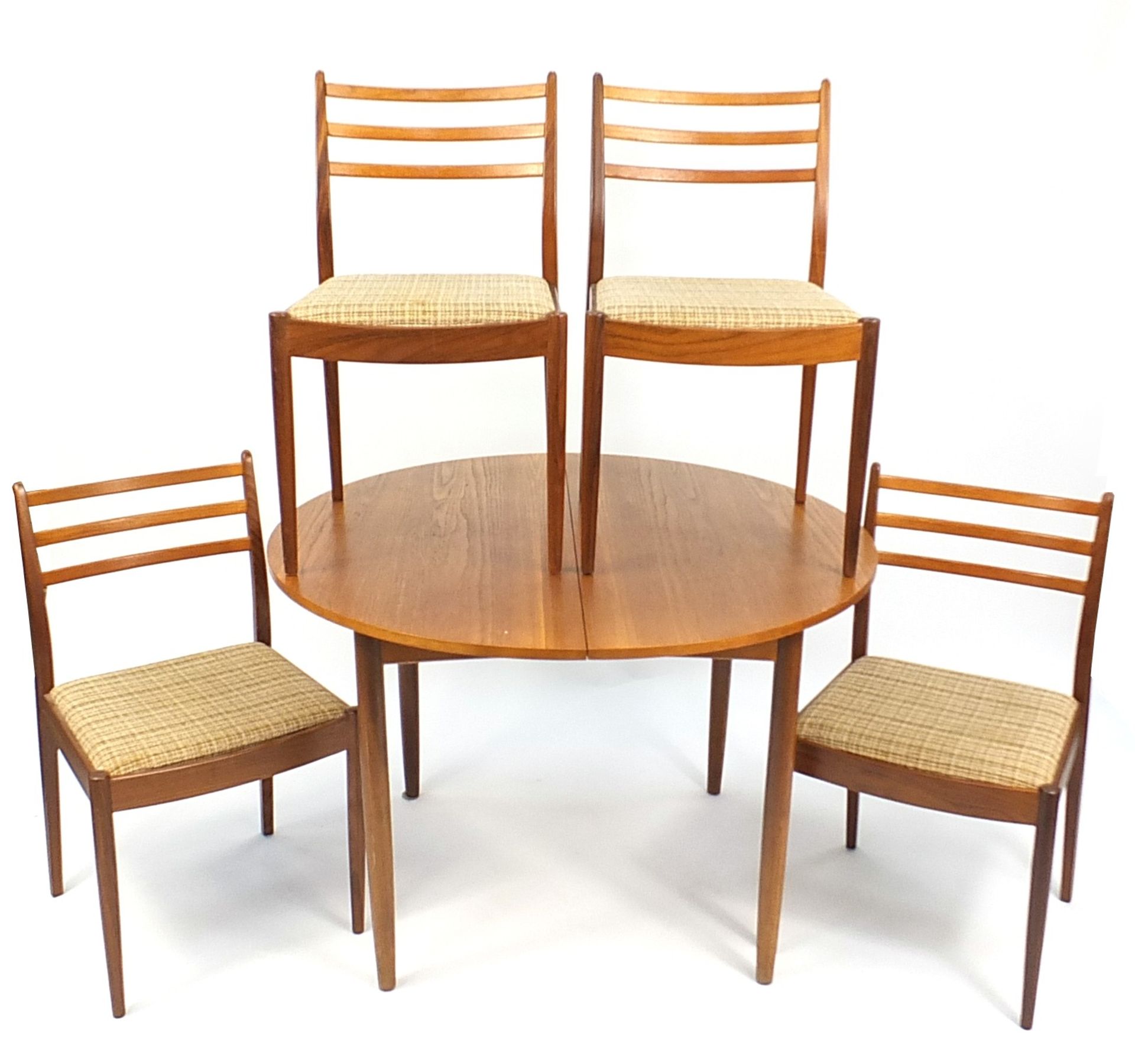 1970's G Plan teak circular extending dining table and four chairs, the table 72.5cm high x 112cm in