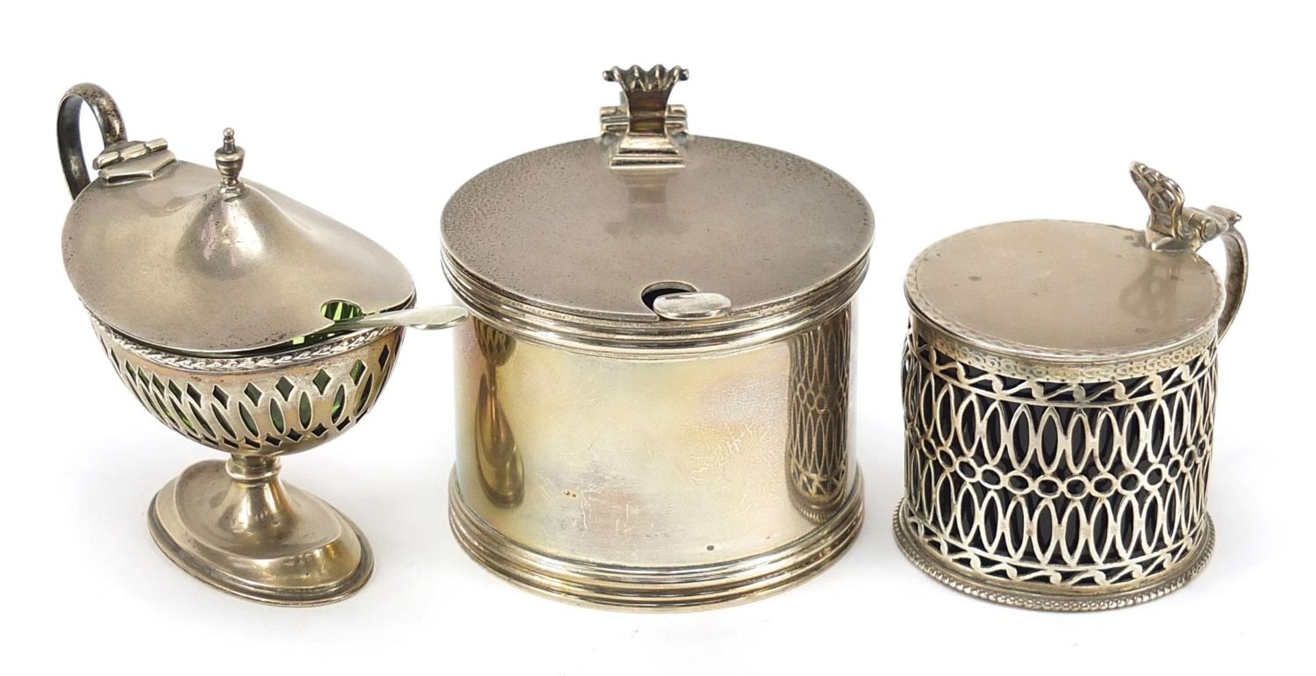 Three antique and later silver mustards with glass liners and two silver plated spoons, the