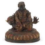 Chinese partially gilt bronzed mythical figure on an animal, 22cm high