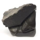 Henry Munyaradzi, Zimbabwean stone sculpture of a figure beneath a rock, signed to the base,