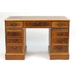 Yew twin pedestal desk with eight drawers, brushing slides and tooled leather insert, 78cm H x 122cm